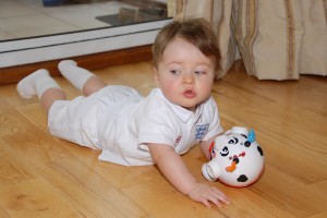 Miss E dressed in a full English Football kit playing with a non-gender specific toy.